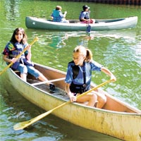 kids paddling canoes